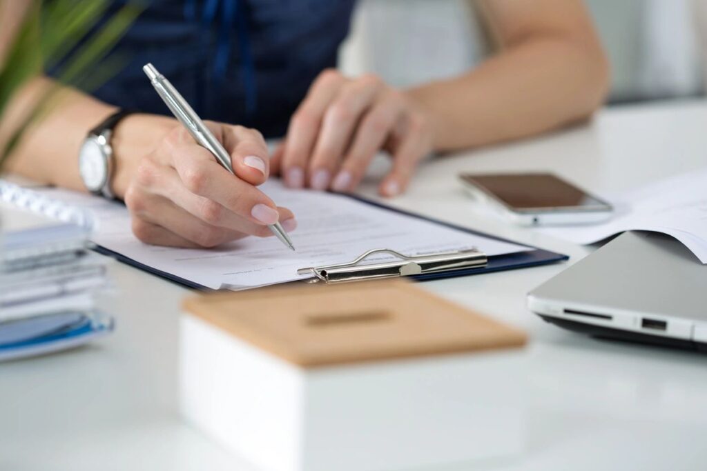 hands writing on a clipboard